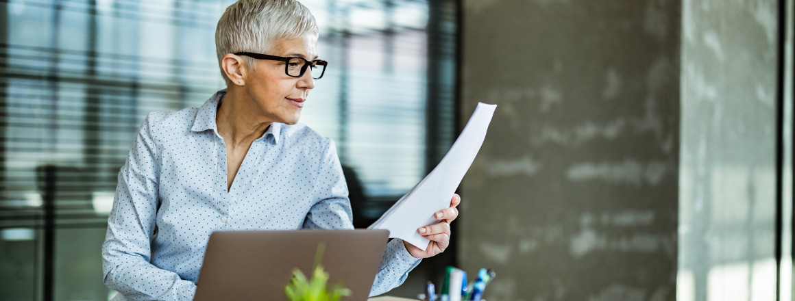Eine Frau studiert im Büro einen CSRD-Bericht